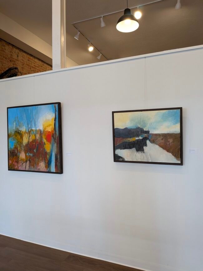 Two abstract landscape paintings by Rusty Lindsey on a white gallery wall at C-ART Gallery on C-Street.