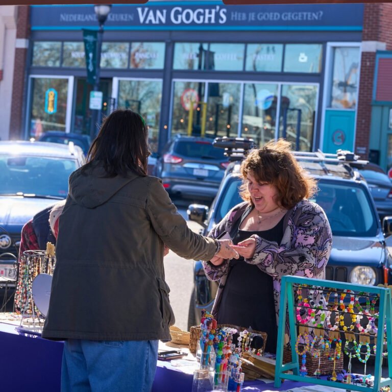 A vendor sells handmade beaded jewelry across from Van Gogh's Eeterie at the C-Street City Market.