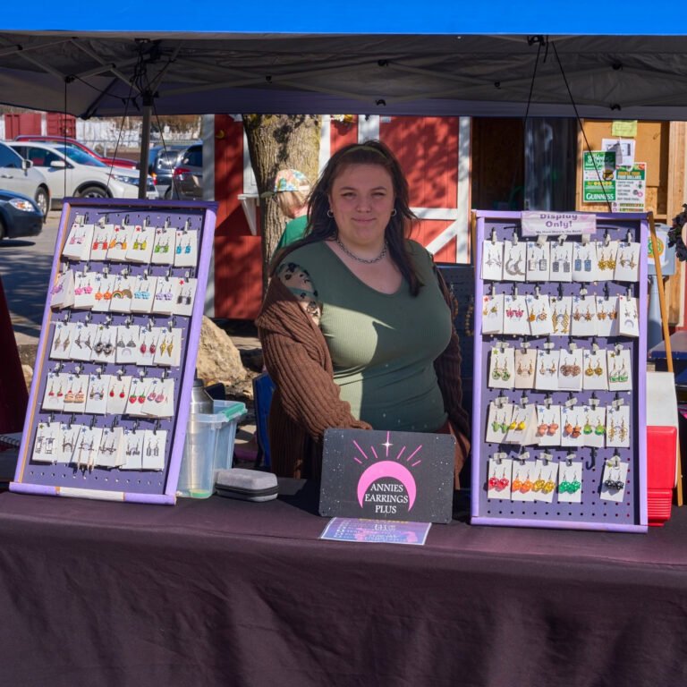 The Annie's Earrings Plus booth with rows of handmade earring displays at the C-Street City Market.
