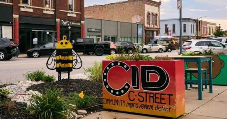 A bee sculpture and a red CID planter sign on Historic Commercial Street, Springfield, Missouri.