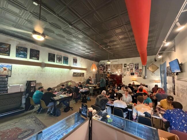 The interior of Dirk's Tavern with patrons and framed photos on brick walls, Historic C-Street, Springfield, MO.