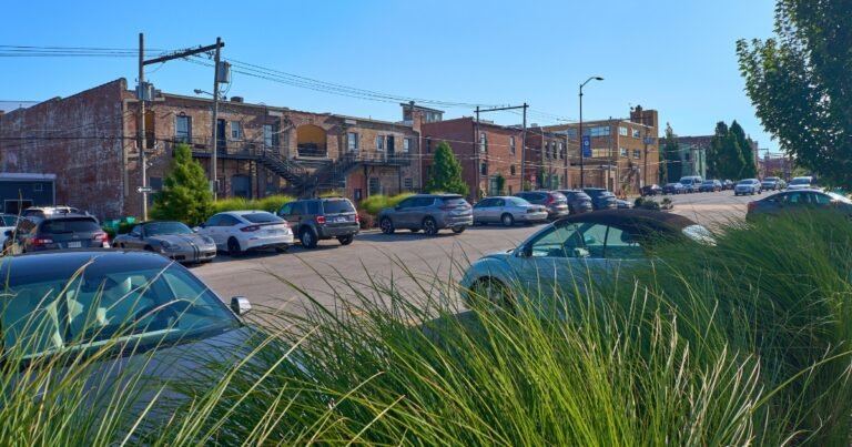 A Historic Commercial Street parking lot with cars and storefronts behind, Springfield, Missouri.