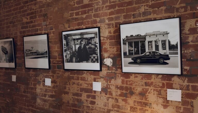 Framed Route 66 photographs hung on a brick gallery wall from the Two Voices One Road exhibit, Springfield, MO.